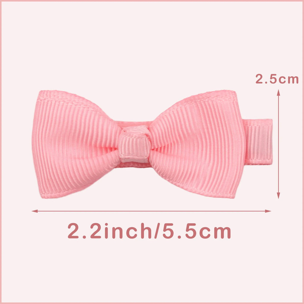 Assortment of pastel-coloured bow and barrette hair clips for babies on a white background.