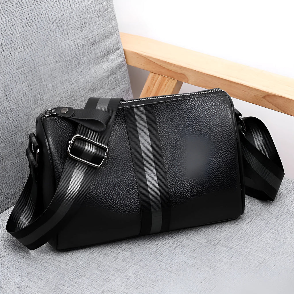 Black genuine leather crossbody bag with one-shoulder strap showing interior polyester lining