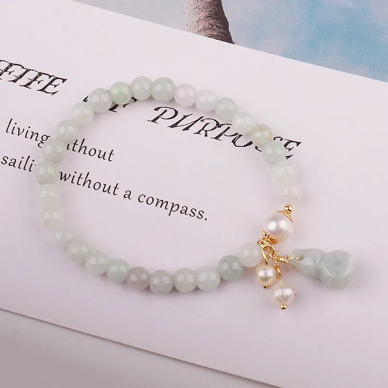 Chinese style jade bracelet with gourd design and pearl accents in natural emerald colour