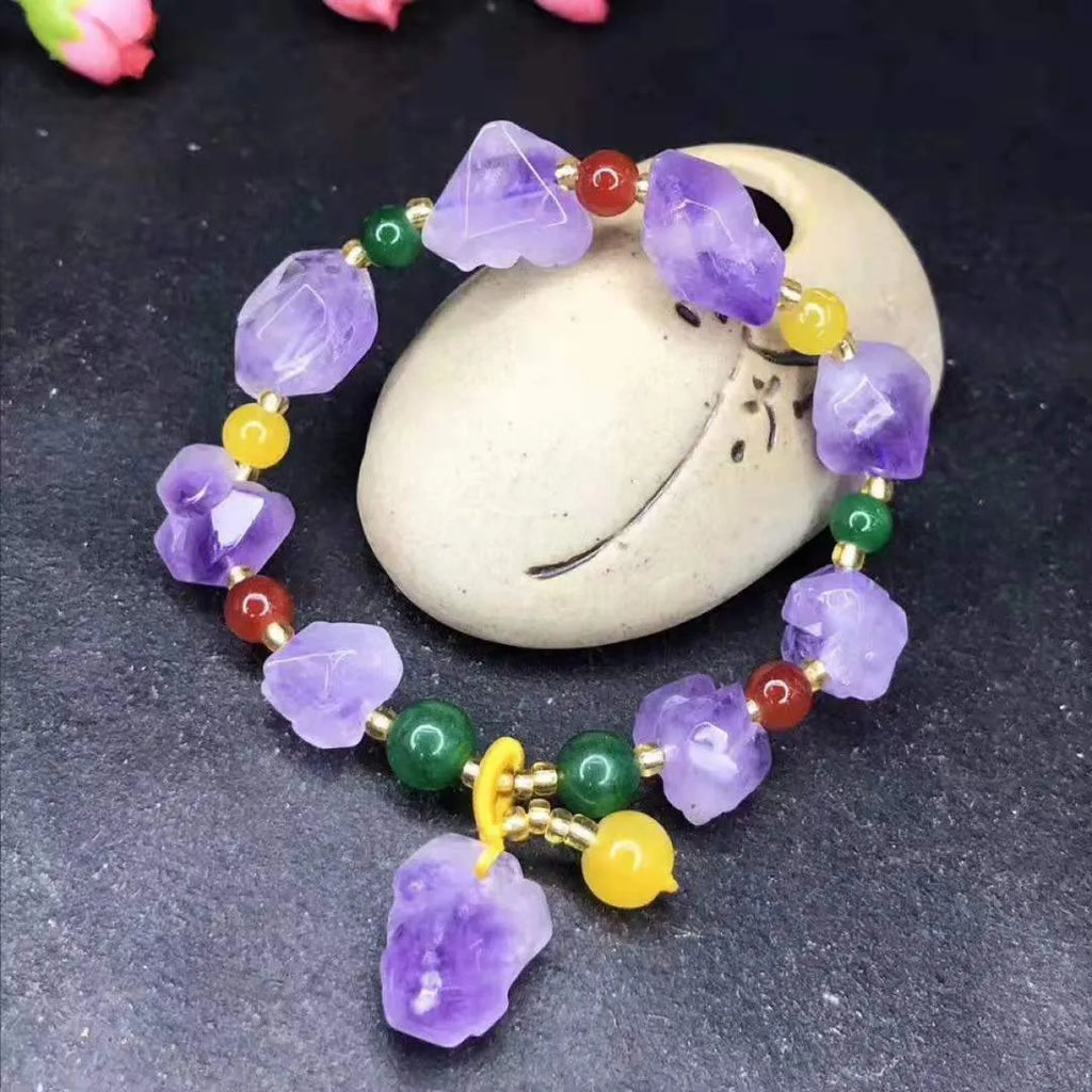 A women's bracelet made of purple natural amethyst beads with a fu character charm.