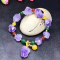 A women's bracelet made of purple natural amethyst beads with a fu character charm.