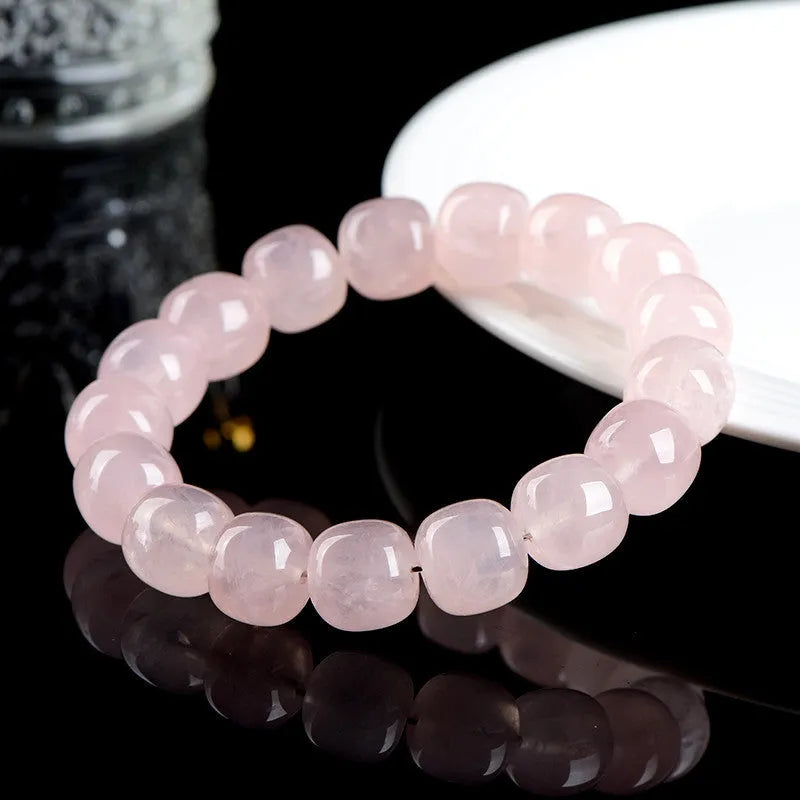 Pink natural bamboo crystal bracelet with 11-12mm geometric barrel beads on a wrist.