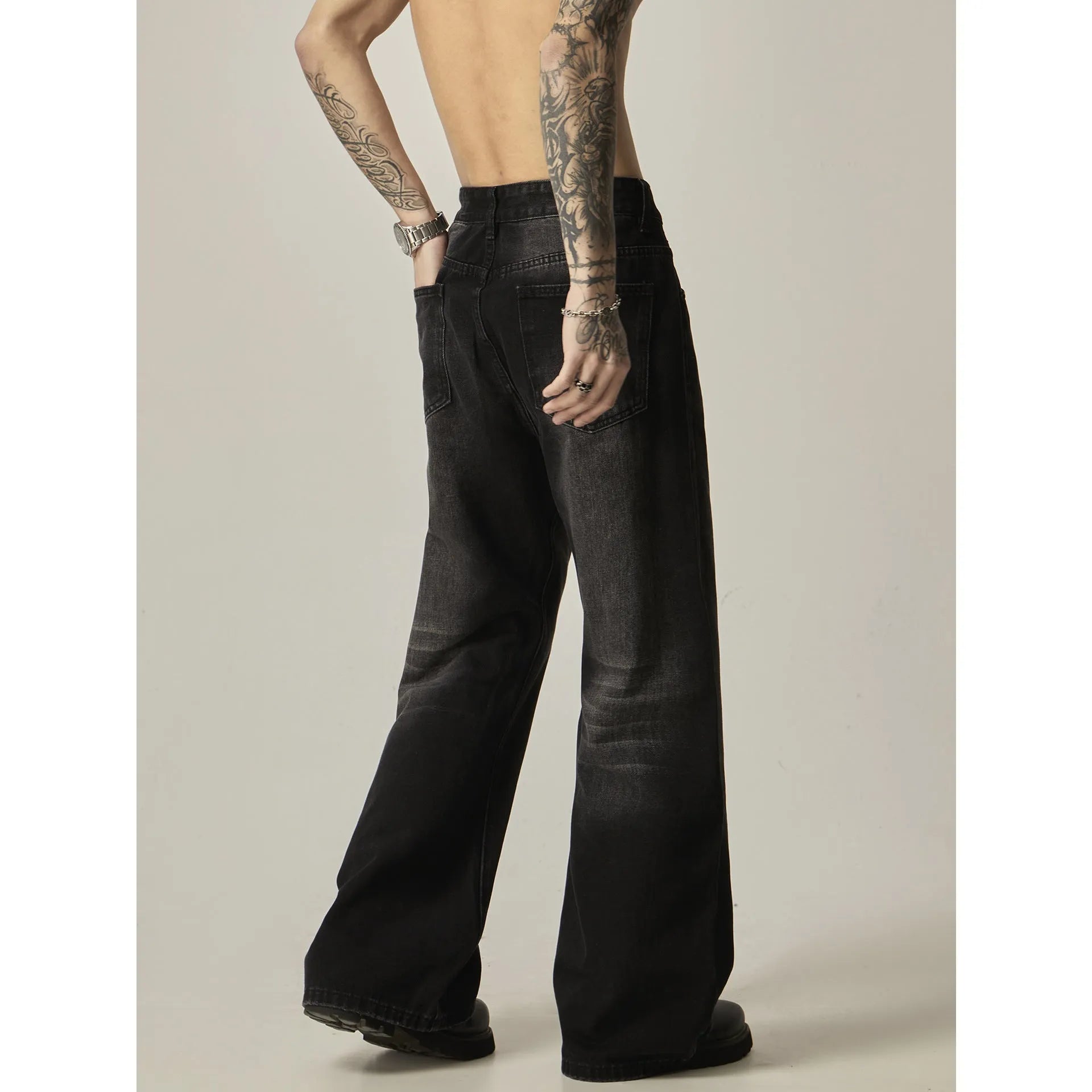 Black loose straight-leg retro jeans on a mannequin, showing zipper fly and relaxed fit.