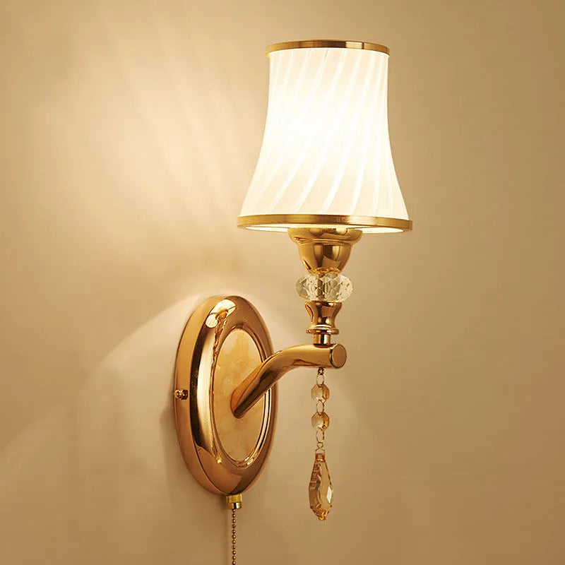 European style glass wall lamp with a fabric cable switch, shown in a bedroom setting.