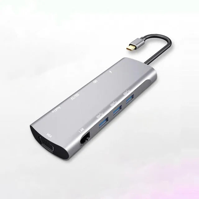 Grey aluminium USB-C docking station with HDMI, VGA, USB ports, and a short cable.