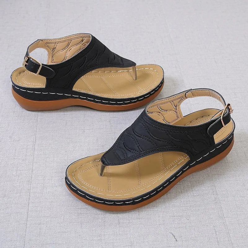 Women's wedge heel flip flop sandals in black with an adjustable buckle strap on the back.
