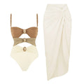 Women's solid colour one-piece swimsuit with gold buttons and a matching skirt.