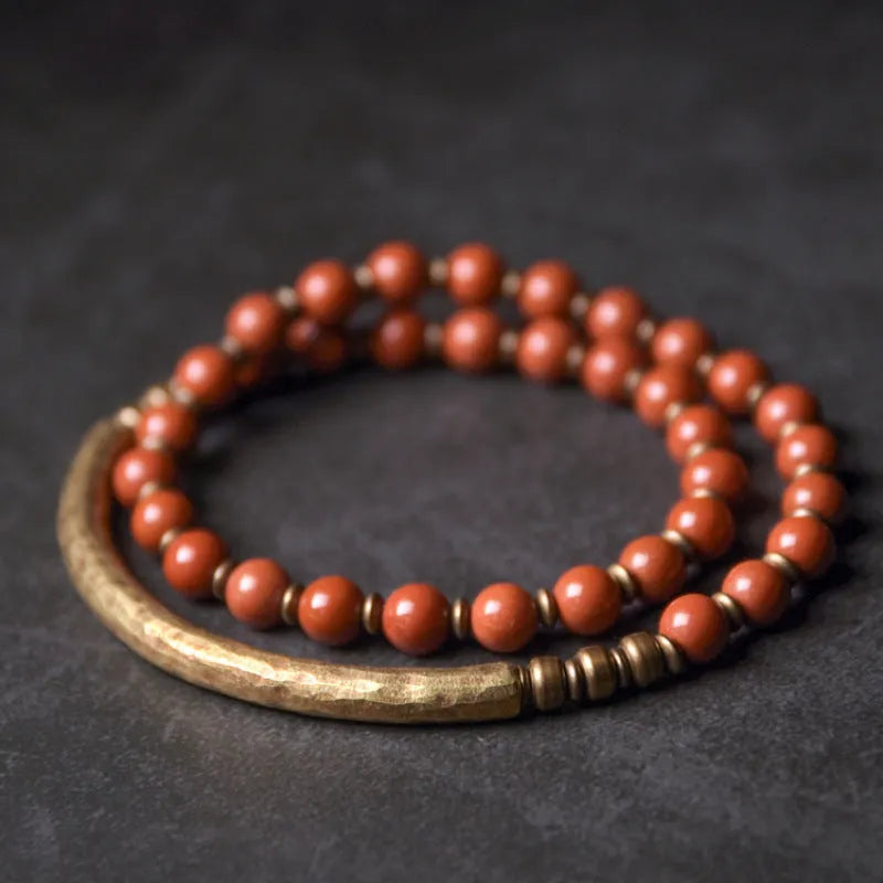 Layered retro ethnic bracelet for men and women with stone beads and brass accents on a wrist.
