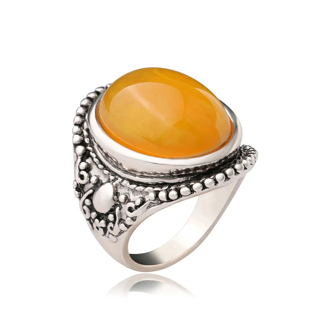 Geometric alloy ring with antique silver and amber electroplated finish shown on a hand.