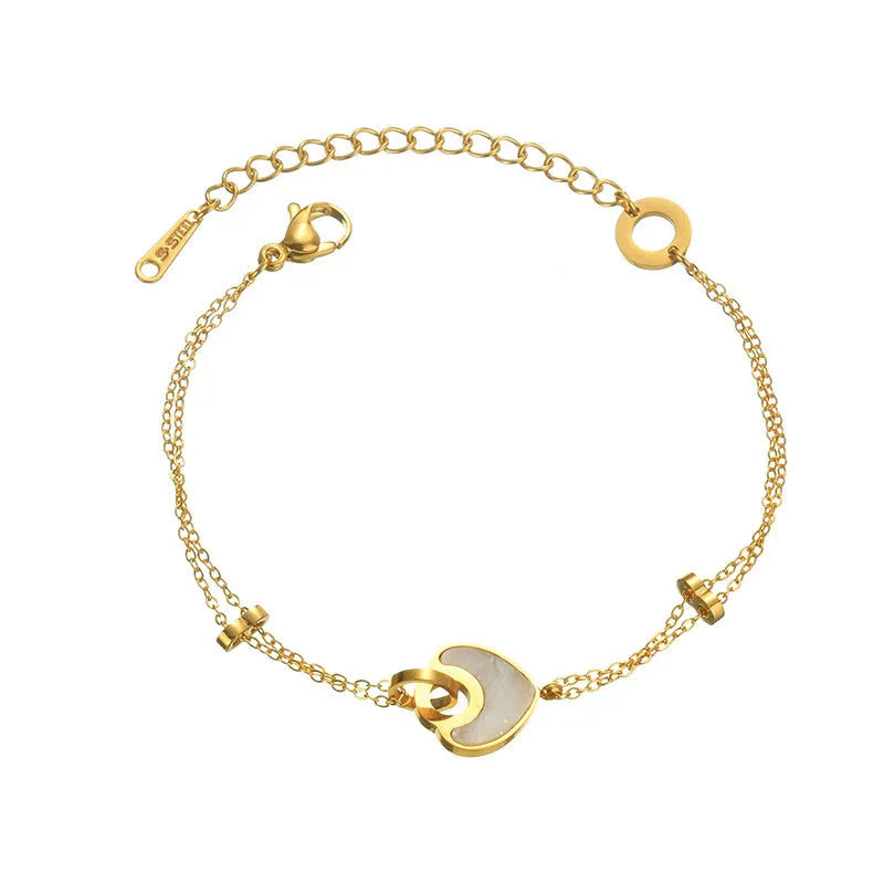 Close-up of a women's stainless steel bracelet featuring a double-layer heart charm with resin details.
