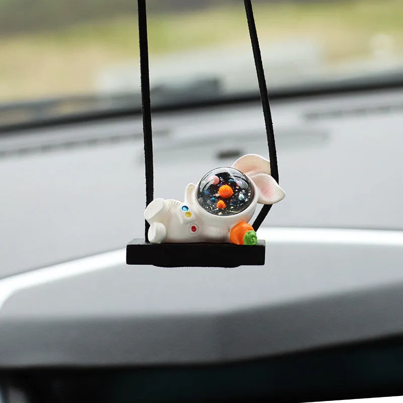 Resin astronaut car pendant showing five cartoon designs including telescope and flag-holding astronauts