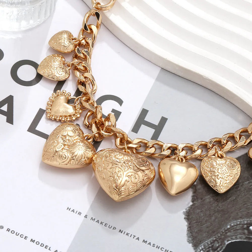 Gold carved heart pendant necklace with adjustable chain on white background