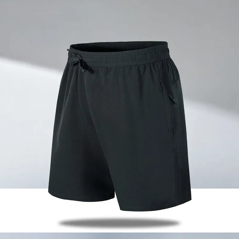 Man wearing loose-fit black quick-drying ice silk polyester sports shorts on a beach.