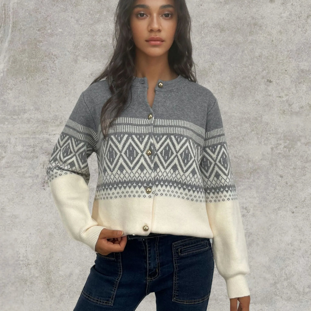 Woman wearing a grey diamond knit cardigan with contrast colour panels, long sleeves.