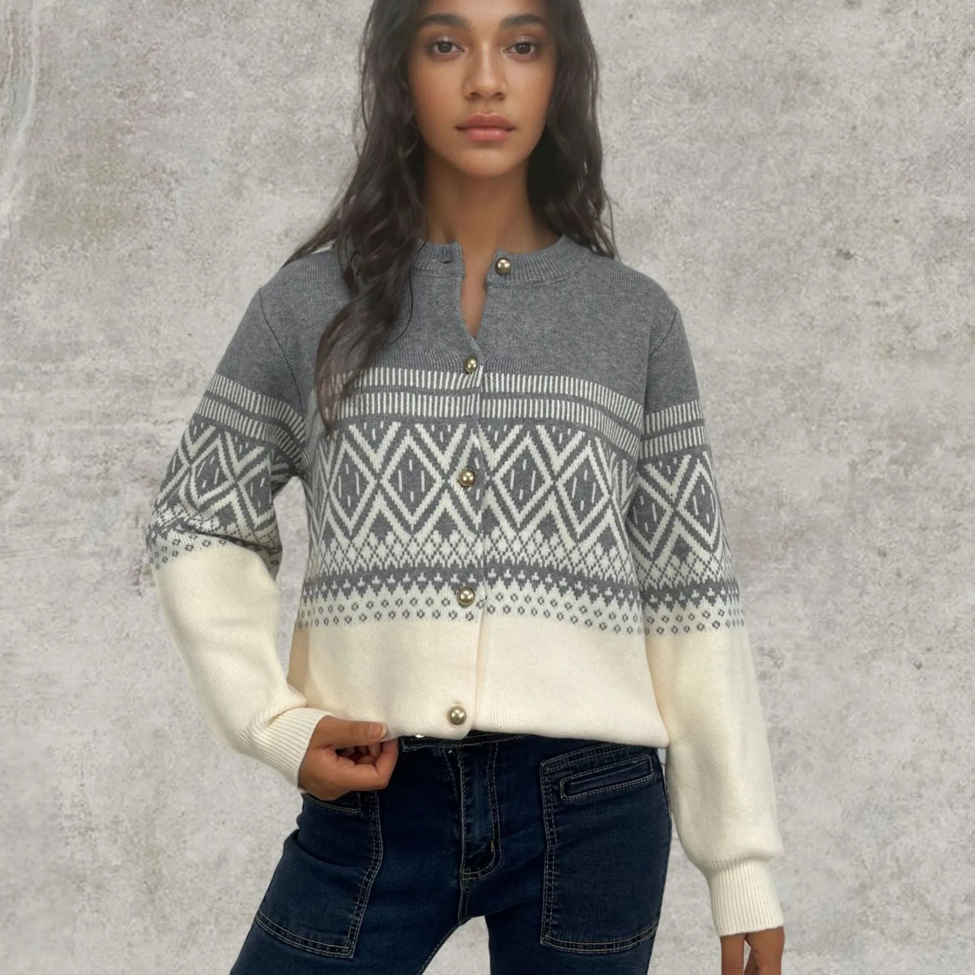 Woman wearing a grey diamond knit cardigan with contrast colour panels, long sleeves.