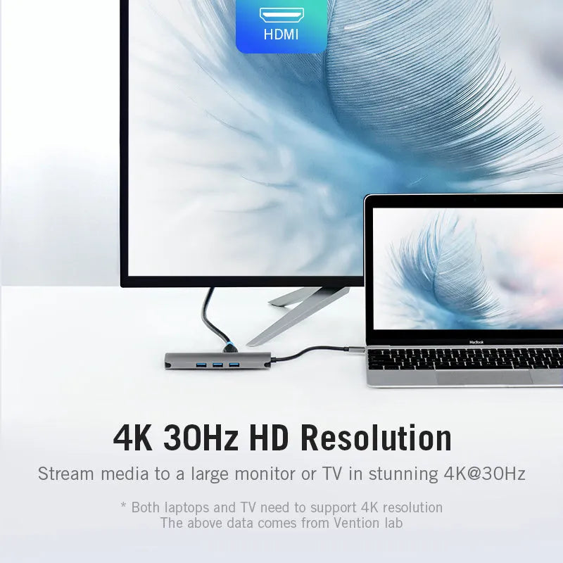 Deep grey USB Type-C to HDMI, USB 3.0, Ethernet, and card reader hub adapter on a desk.