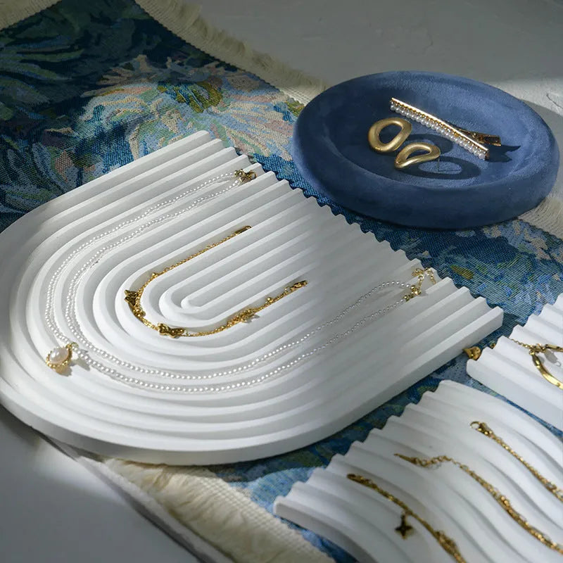 Handmade plaster jewellery display tray with necklaces and bracelets on a countertop