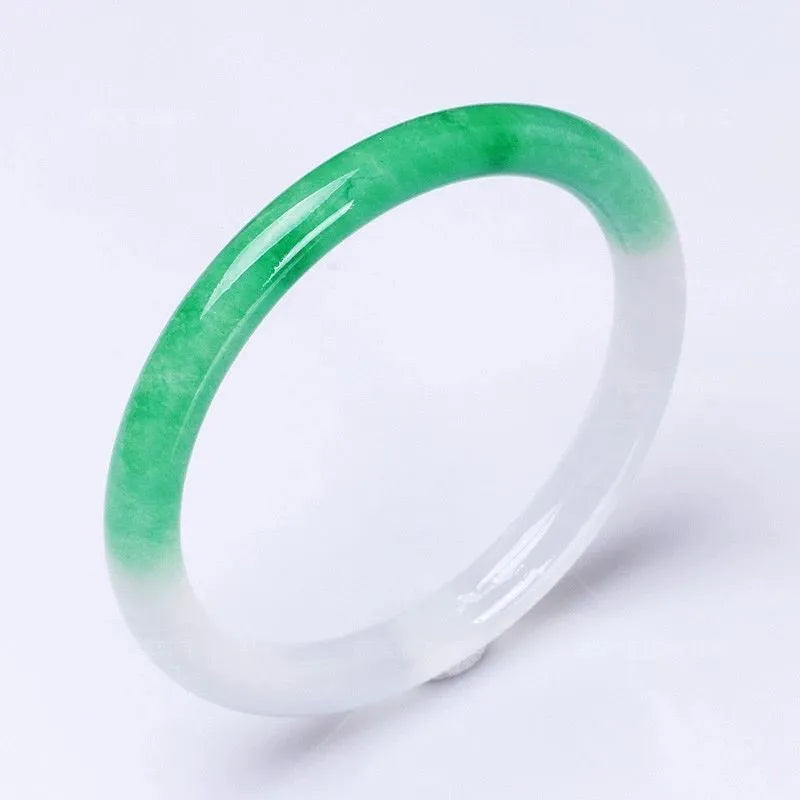 Jade bracelet with carved floating flower and auspicious cloud pattern in emerald green.