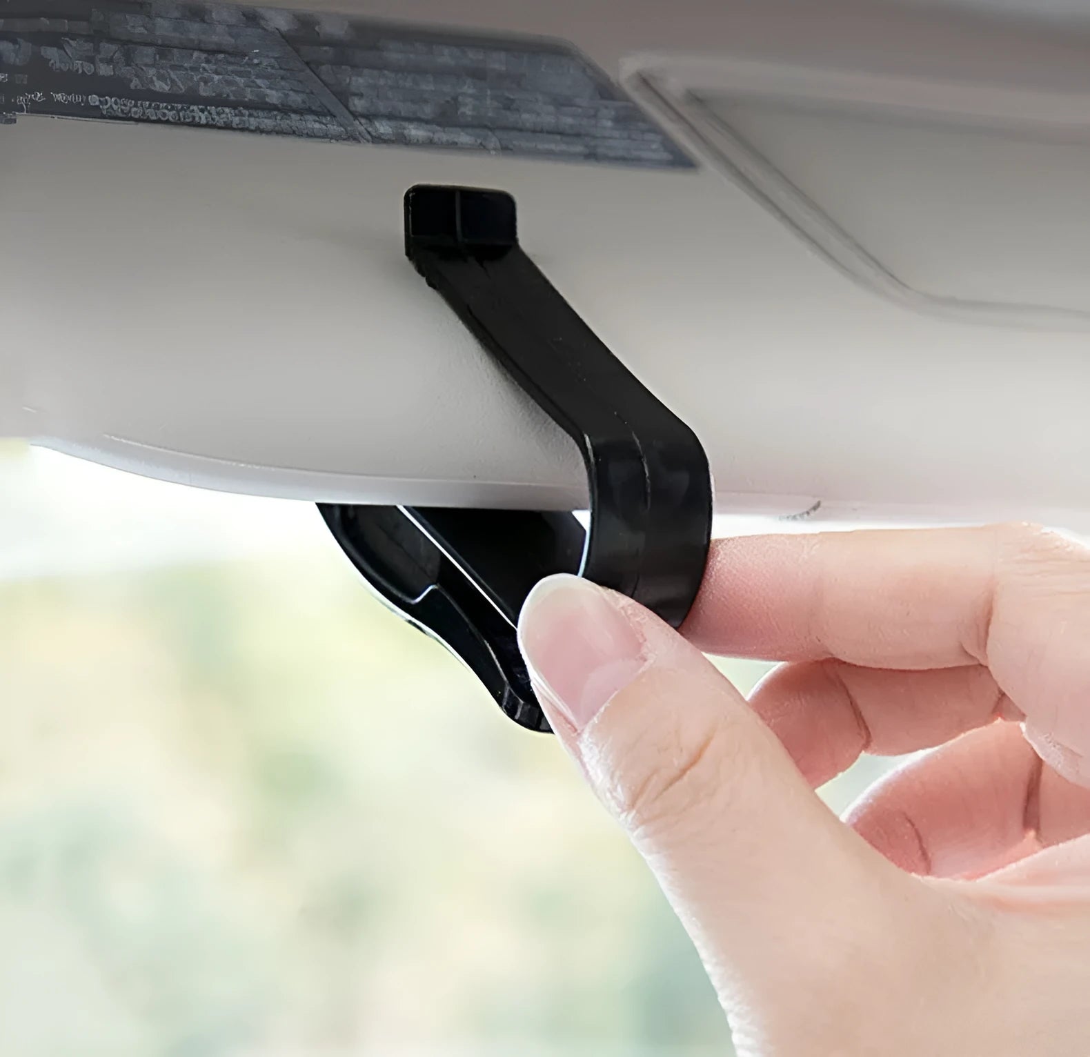 Black plastic clip for holding glasses and cards on a car sunshade