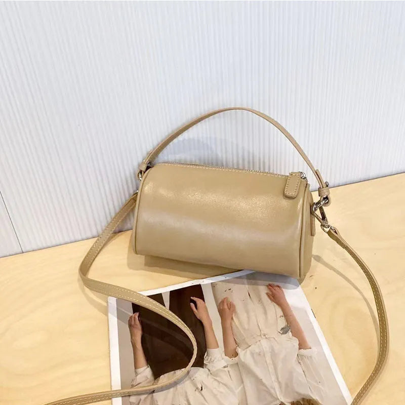 Soft brown genuine leather cylindrical crossbody phone bag with adjustable strap.