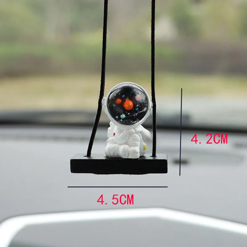 Resin astronaut car pendant showing five cartoon designs including telescope and flag-holding astronauts