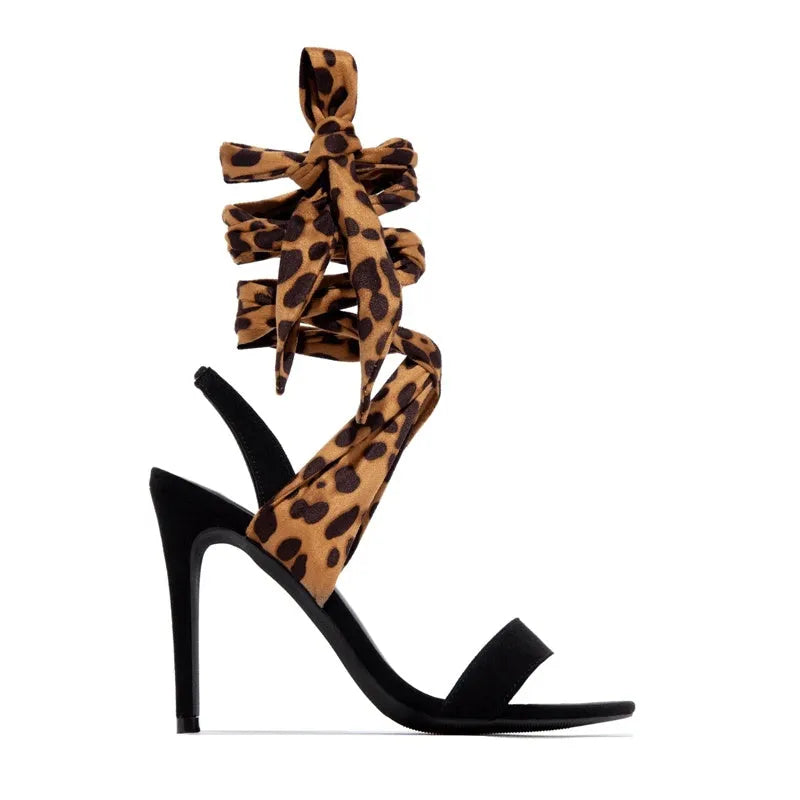 Light brown leopard print women's high heel sandals with cross straps and a fine heel.