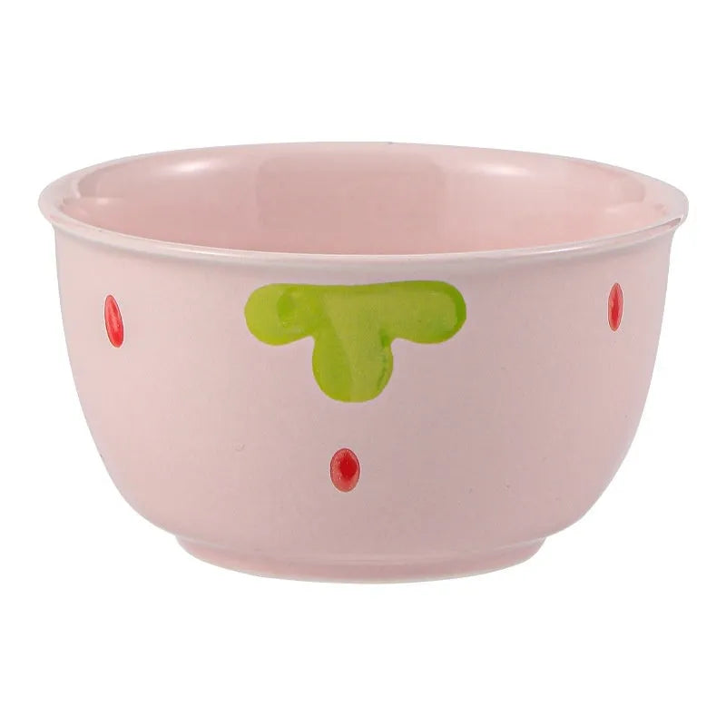 Cute strawberry pattern porcelain dinnerware set showing bowl, plate, and twist spoon on a table.