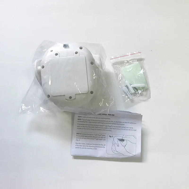 White Atomic Angel induction light lamp on a surface showing its compact size.