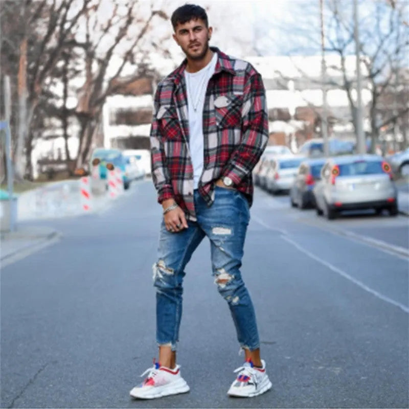 Men's deep blue distressed jeans with hole details on the legs.