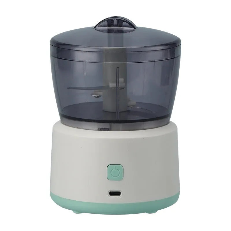 White and light green mini electric meat grinder with stainless steel blade on kitchen counter