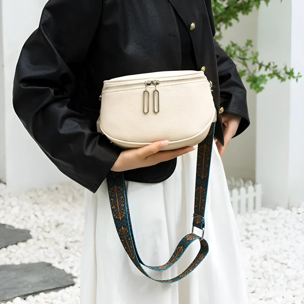 Women's soft PU messenger bag in saddle shape with single shoulder strap and zippered interior compartment