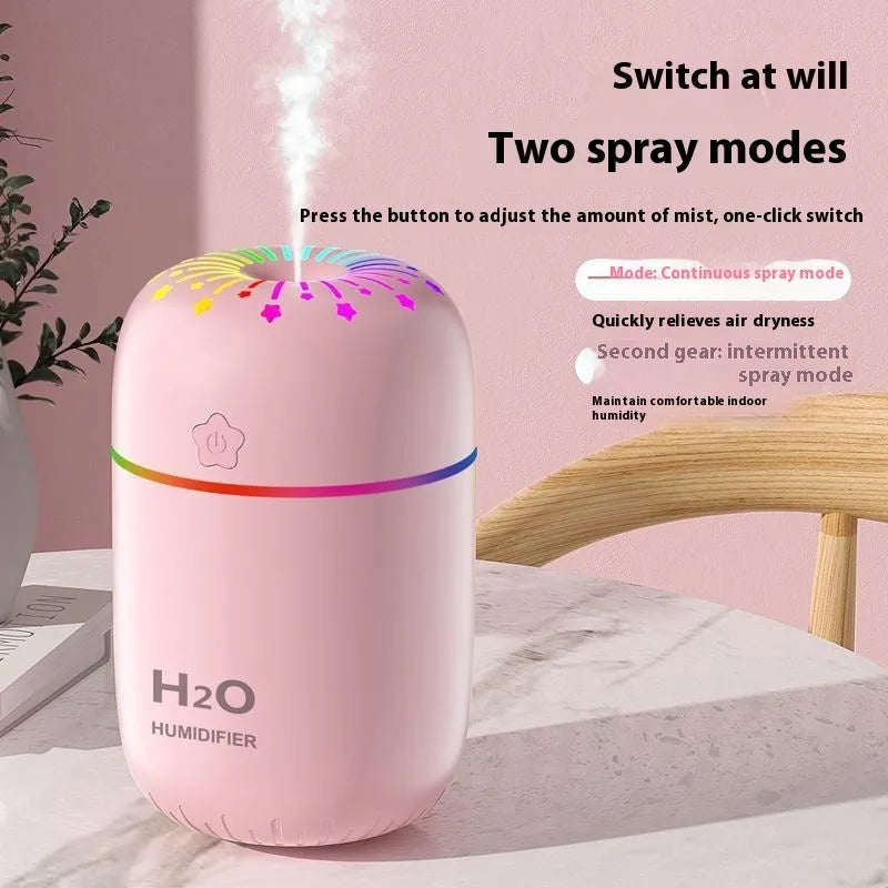 Small white USB personal humidifier with water tank on a wooden desk.