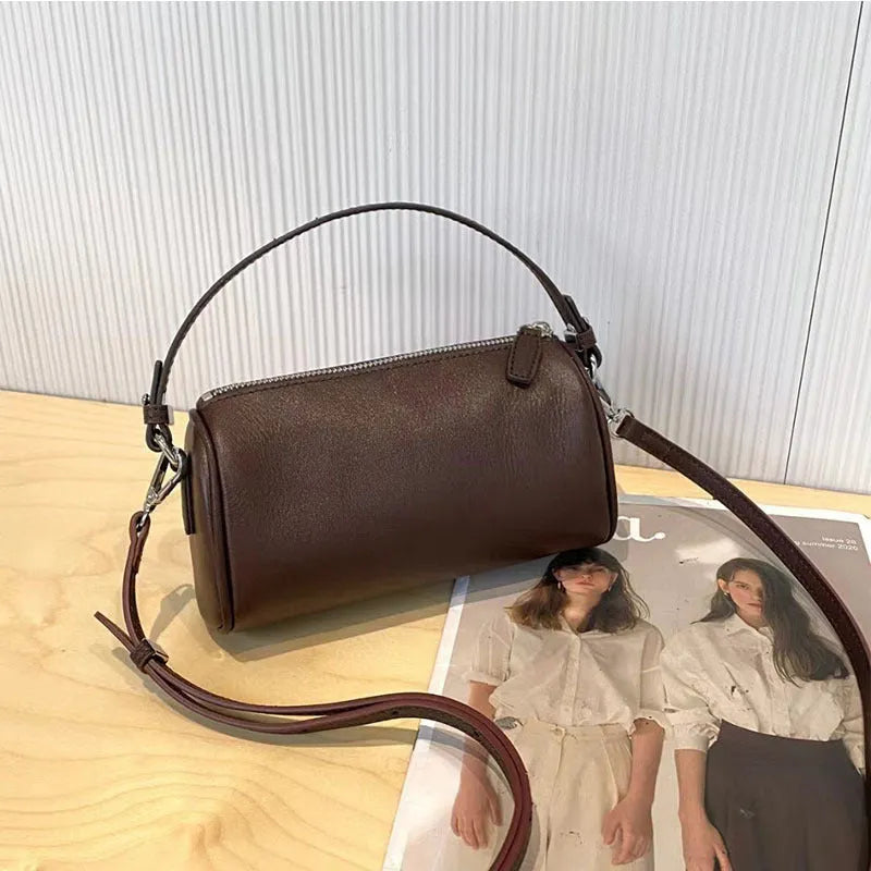 Soft brown genuine leather cylindrical crossbody phone bag with adjustable strap.