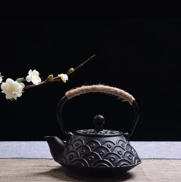 Japanese cast iron teapot in black with Peony pattern, showing lid, handle, and spout.
