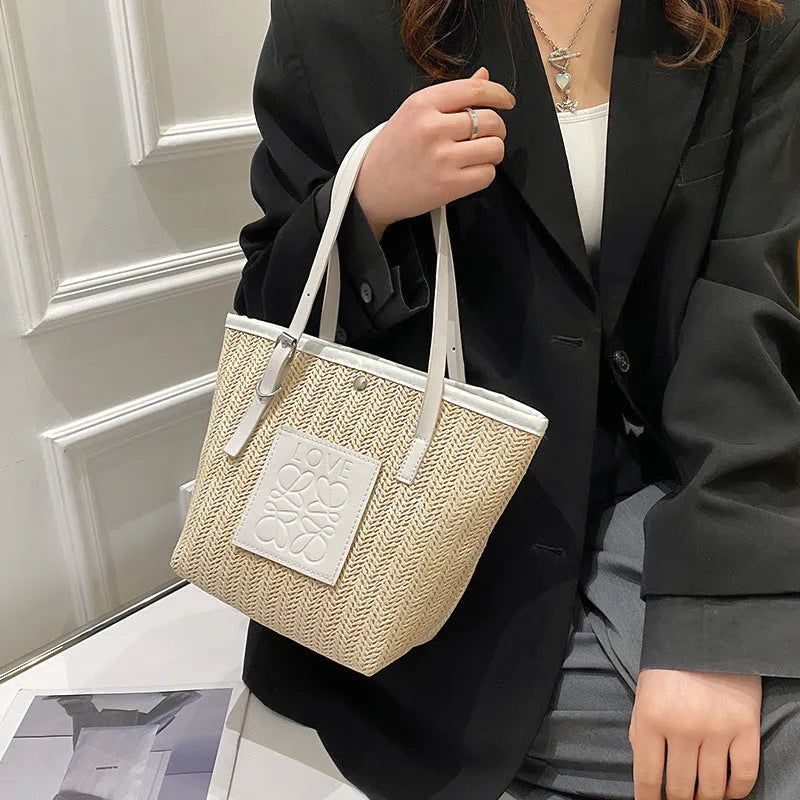 Women's woven straw shoulder bag in retro style with three-dimensional pocket and visible sewing thread details