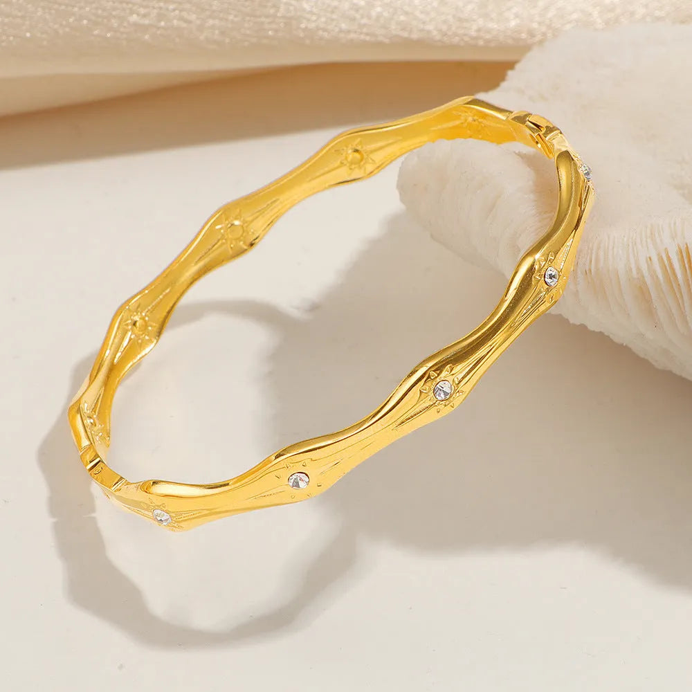 Titanium steel 18K gold electroplated bracelet with round zircon accents in SZ67 Gold colour on a plain background