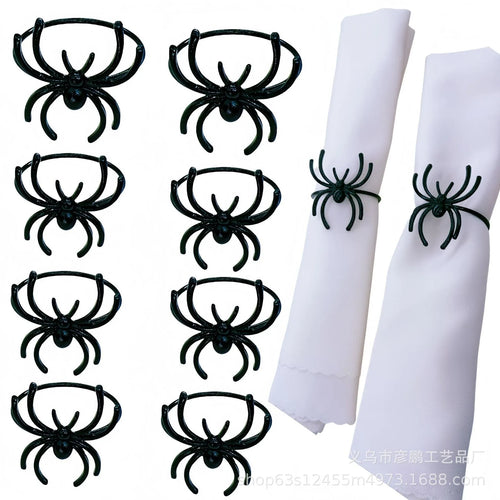 Set of six black alloy spider-shaped napkin rings for Halloween table decoration.