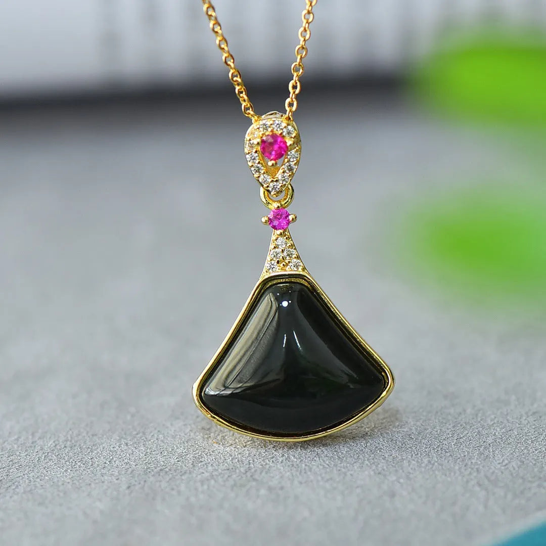 Close-up of a natural Hetian jade pendant with intricate copper inlay detail on a necklace chain.