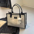 Women's black canvas tote bag with rhombus pattern showing sandwich pocket organisation interior