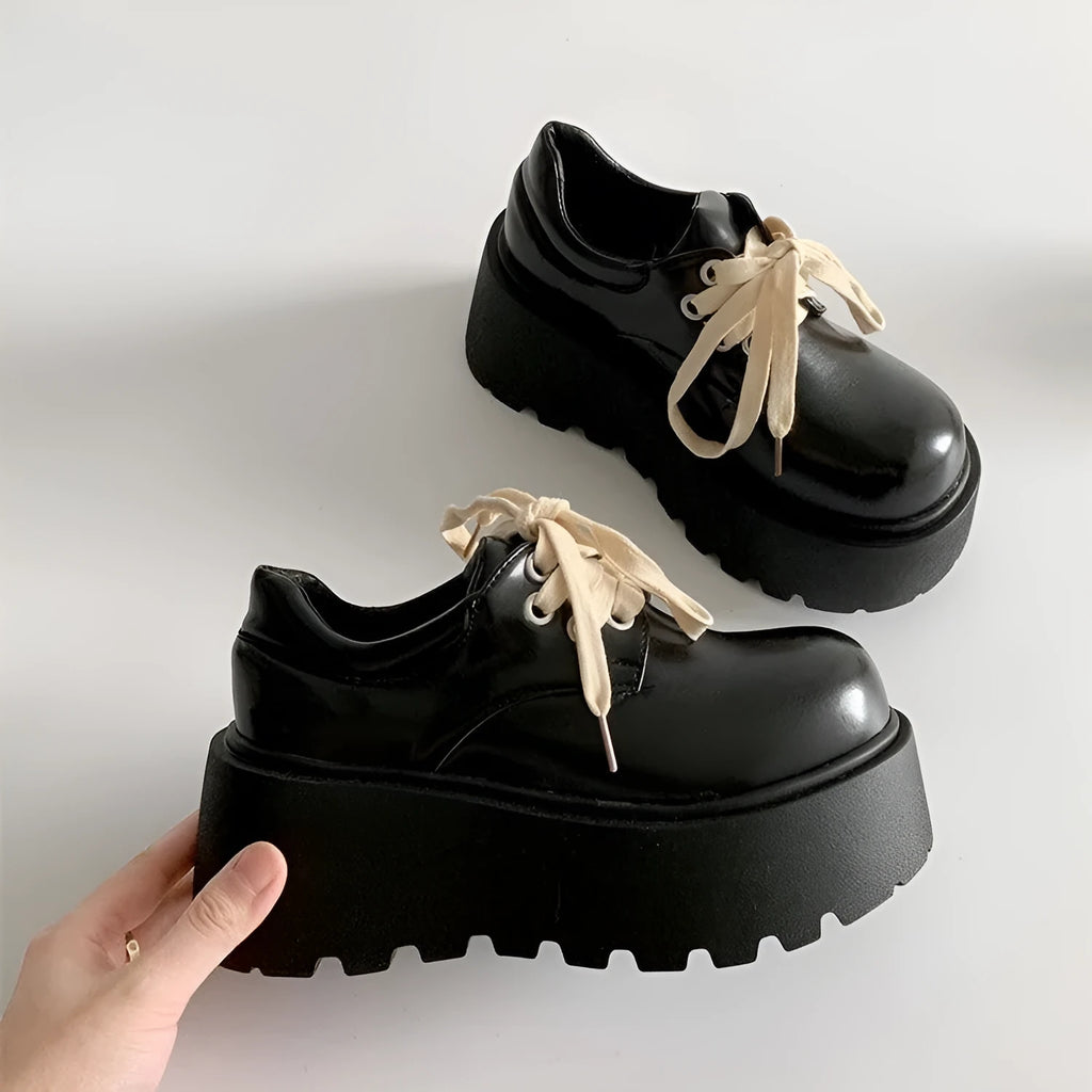 Women's matte black retro platform shoes with chunky rubber sole and lace-up buckle.