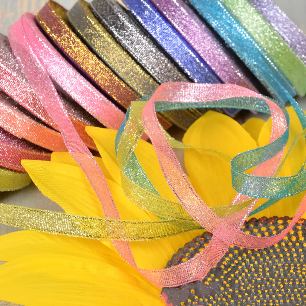 Spool of green onion patterned ribbon in gold silk and silver polyester on a 3-point reel.