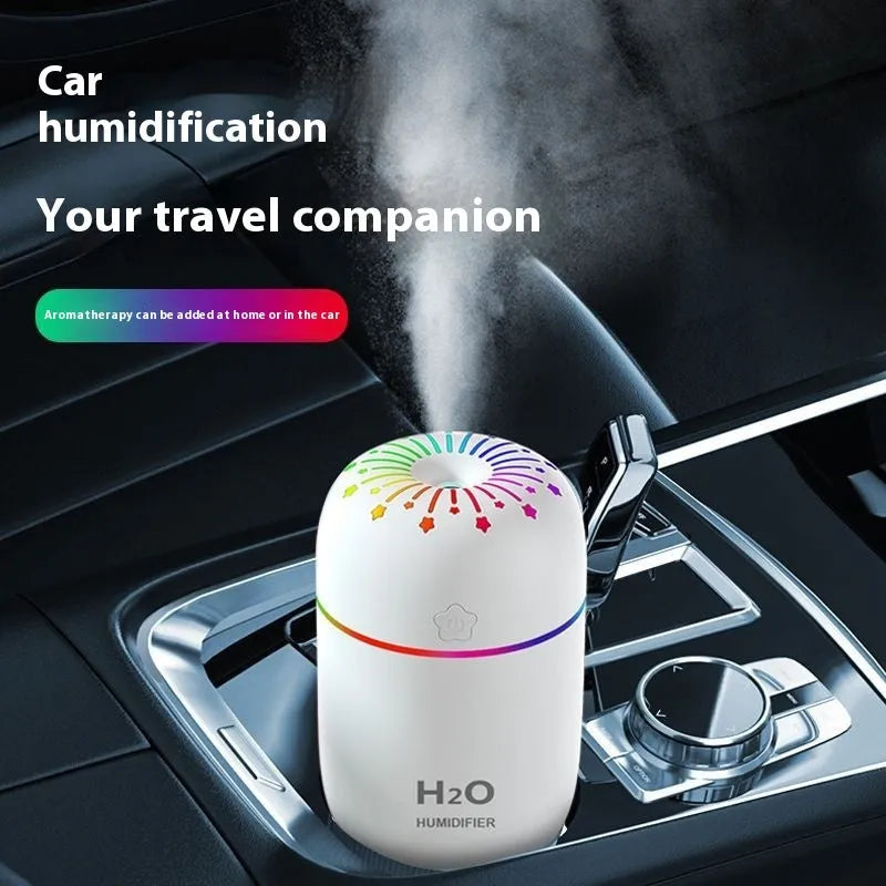Small white USB personal humidifier with water tank on a wooden desk.