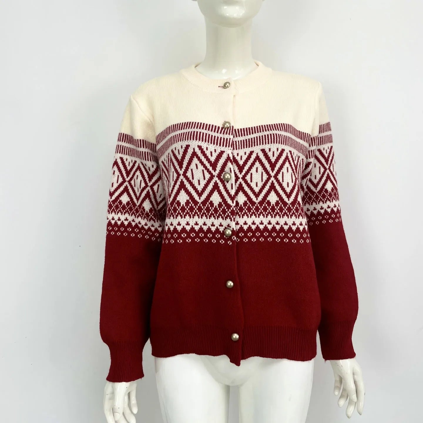 Woman wearing a grey diamond knit cardigan with contrast colour panels, long sleeves.