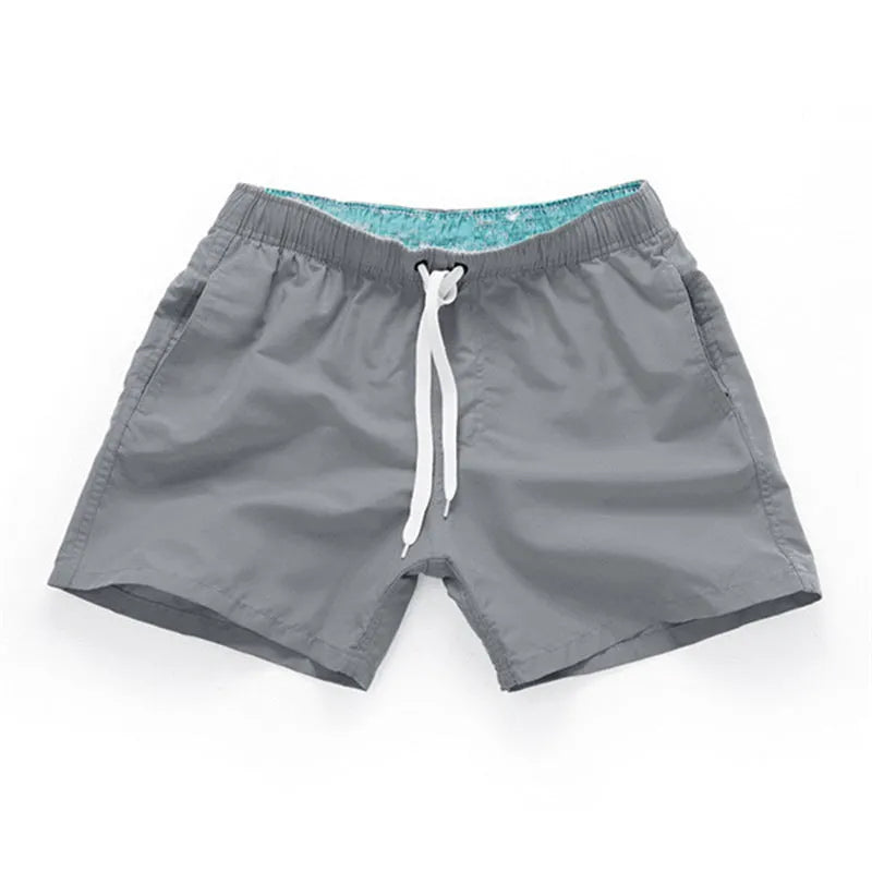 Men's straight-leg beach shorts in polyester fabric on a beach background