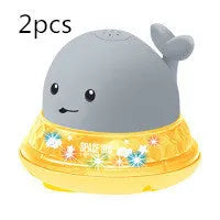 Blue and white whale bath toy with water spray and flashing lights for baby sensory play