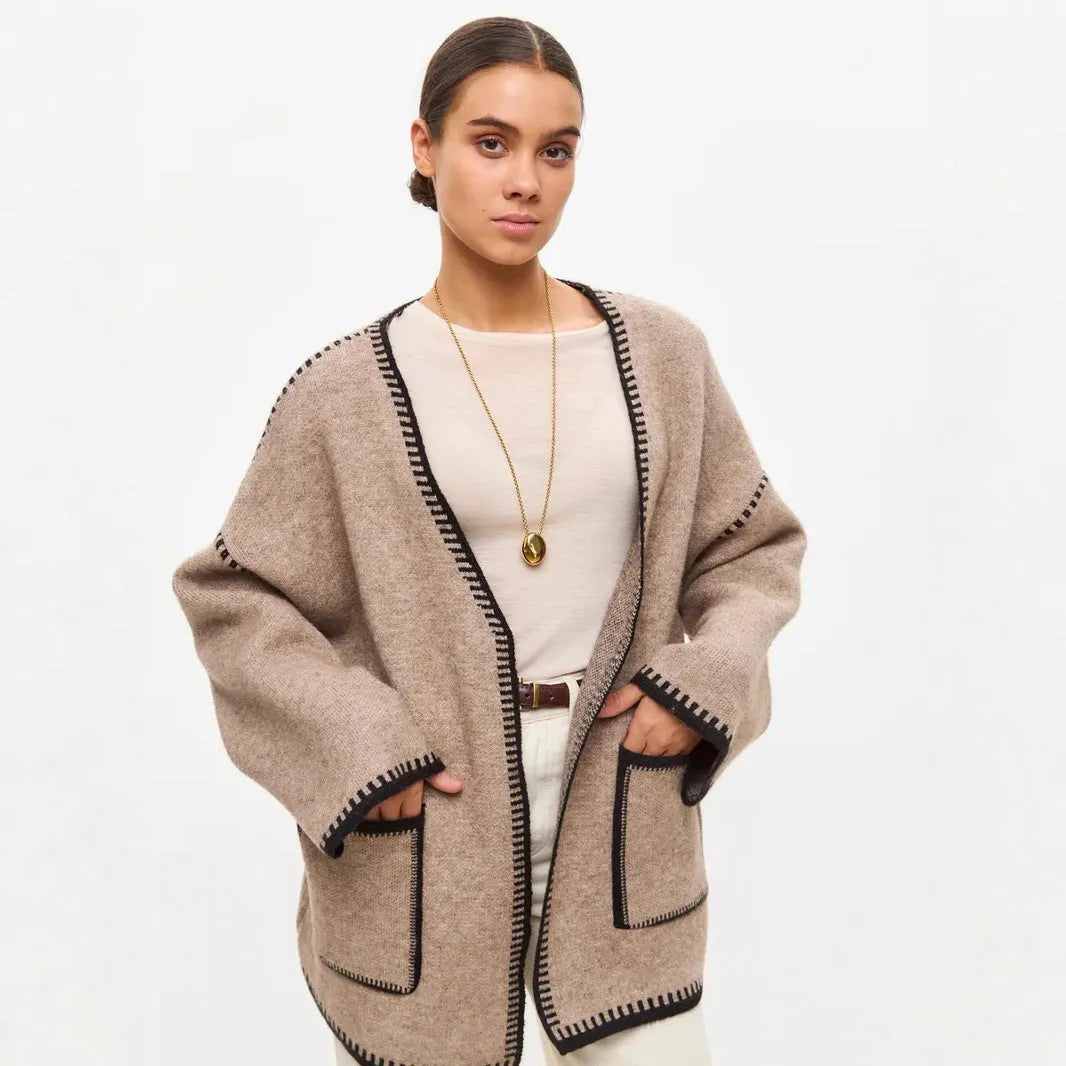 A loose, mid-length knitted cardigan with a front lace-up detail, shown in a camel colour.