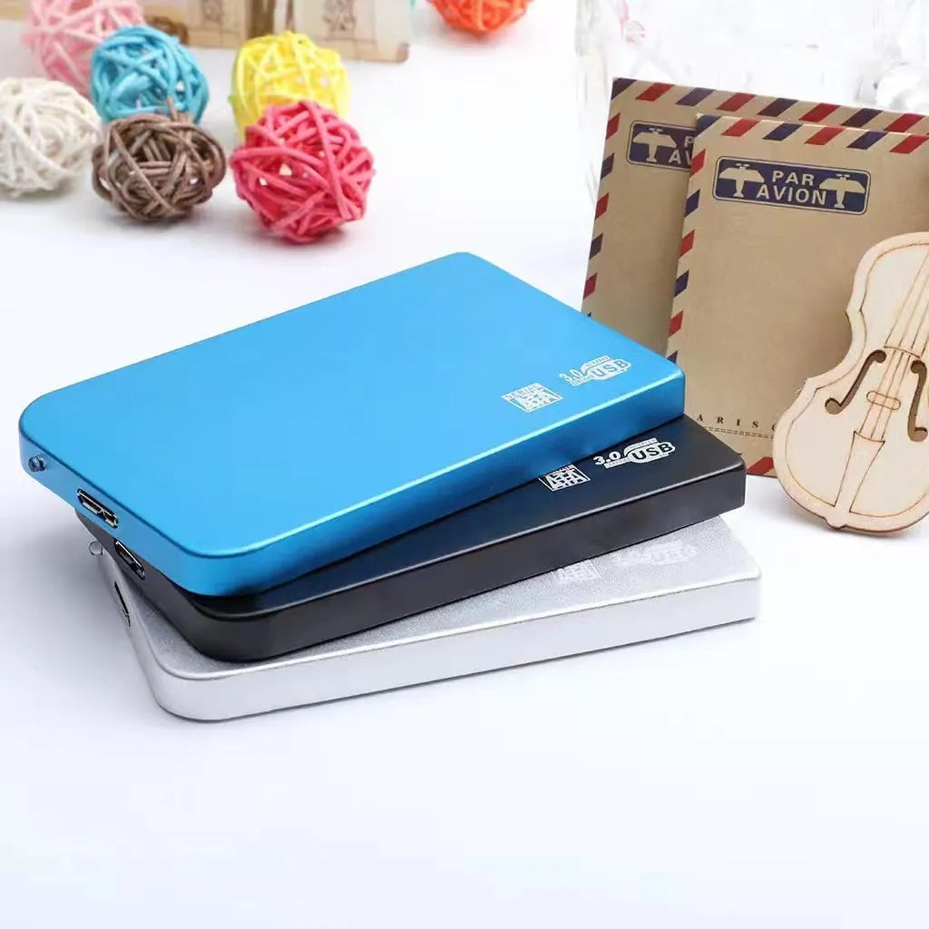 Silver metal USB 3.0 solid-state mobile hard drive with data cable on a desk.