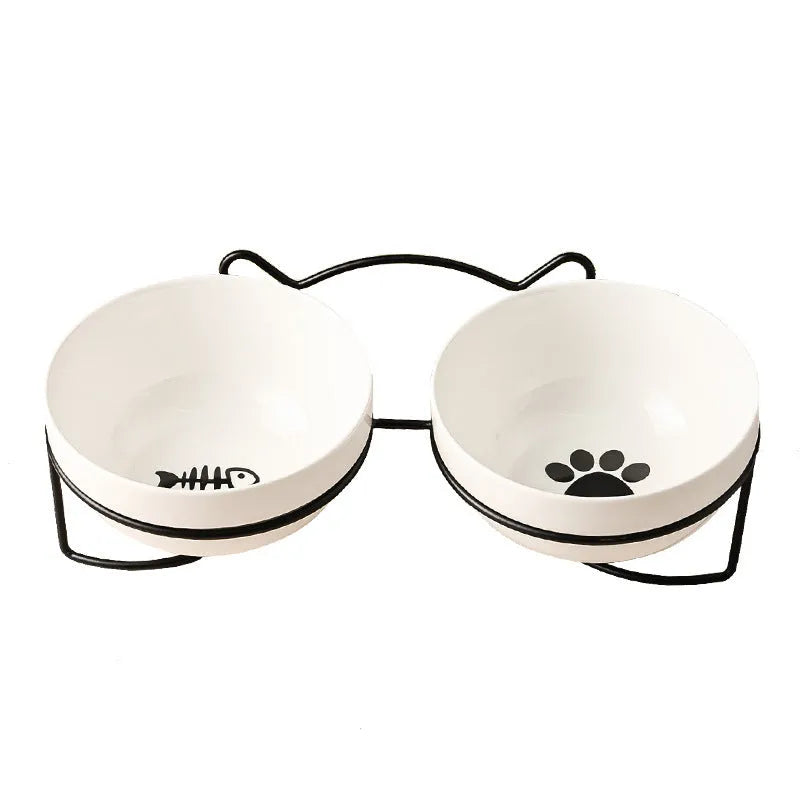White ceramic pet bowl with cat footprints design in a black iron frame.
