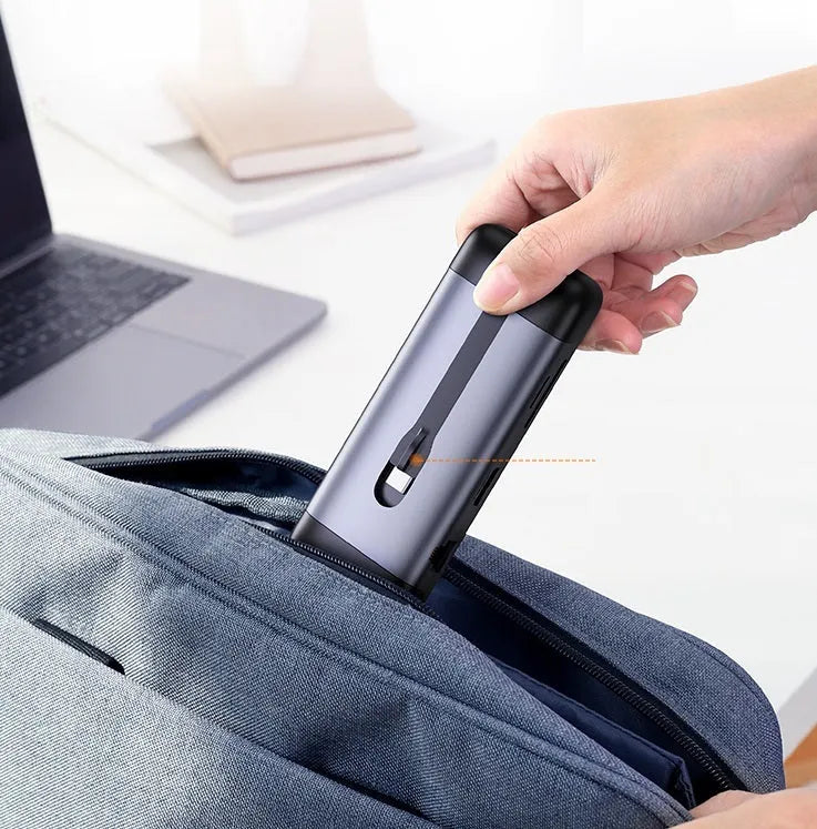 Black USB-C docking station hub showing multiple ports including HDMI, USB, and ethernet, with a short connecting cable.