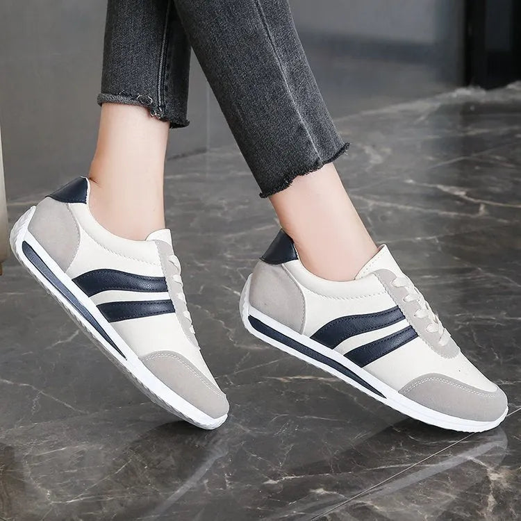 Red low-top lace-up running sneaker with round toe and rubber sole.